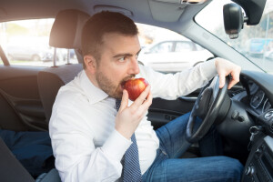 Man Eating Apple In Car