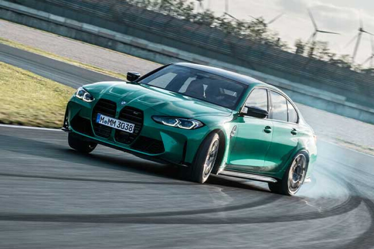 2021 BMW M3 Competition drifting on a racetrack.