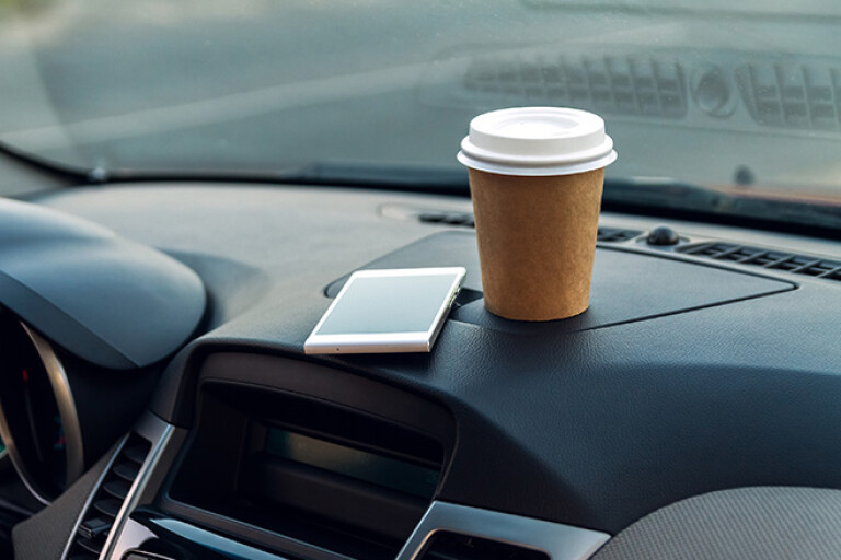 Mobile Phone and Coffee Cup on Dash