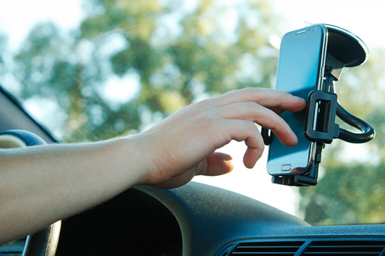 Man touching phone on windscreen