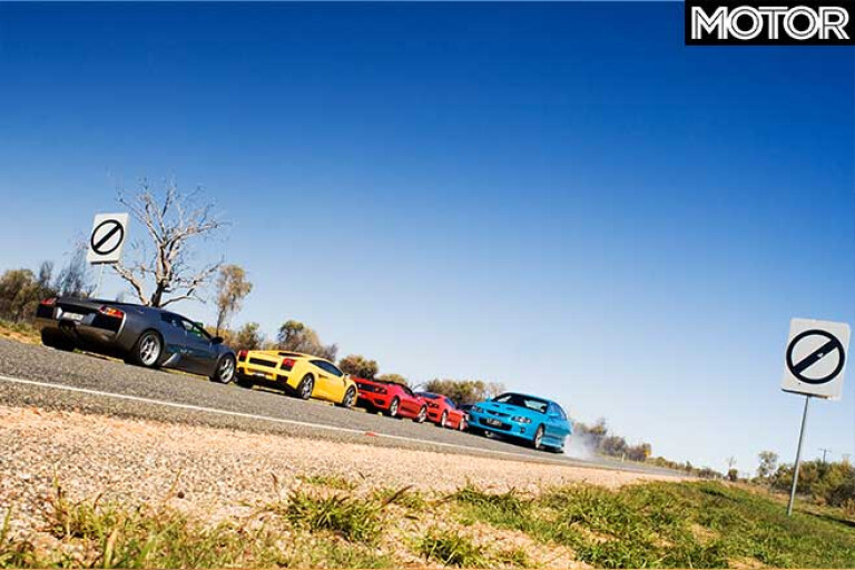 Holden Monaro CV8 doing a burnout in front of a group of supercars.