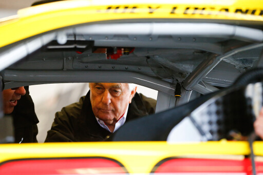 Roger Penske inspecting NASCAR vehicle