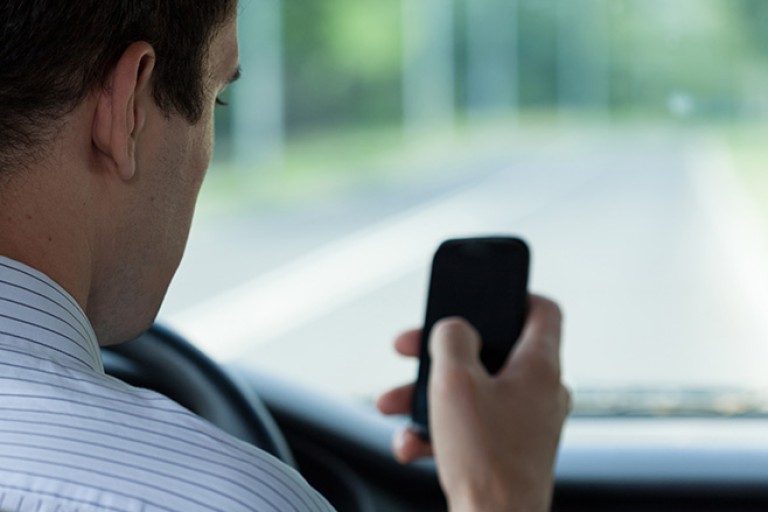 Man using mobile phone while driving.