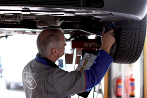 mechanic examining underneath car