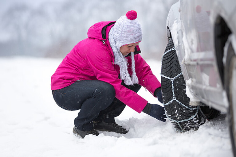 Woman fitting snow chains