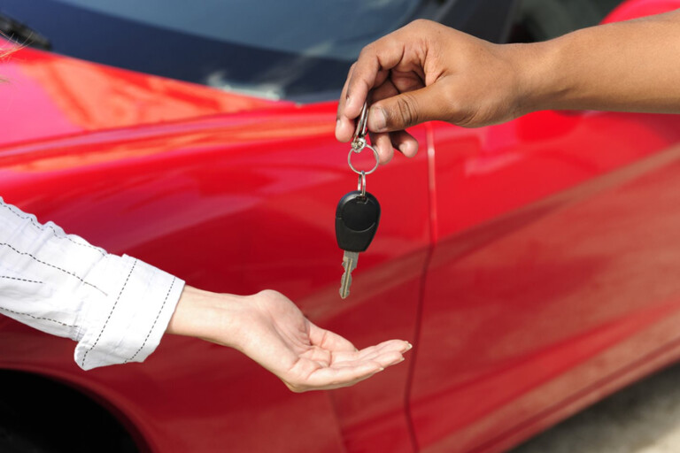 New car buyer collecting keys from car dealer