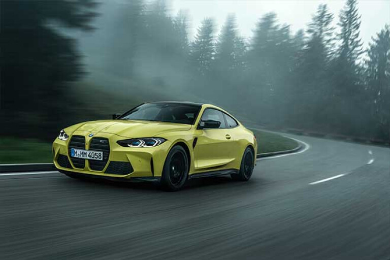 2021 BMW M4 Competition driving on a mountain road.